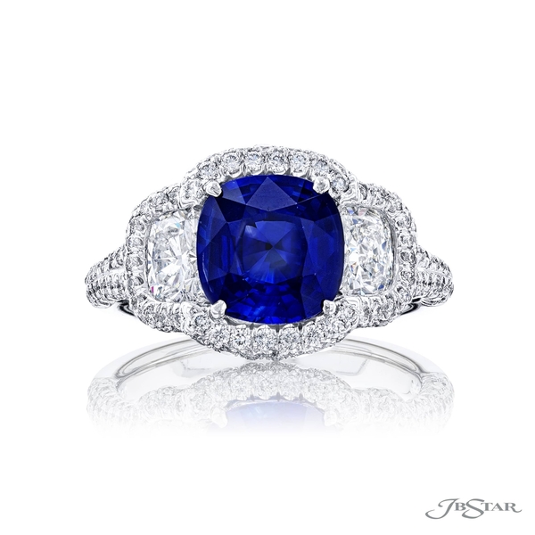 Sapphire and diamond ring featuring a 2.46 ct. cushion-cut sapphire embraced between two cushion-cut diamonds in a micro pave setting. 7053-005